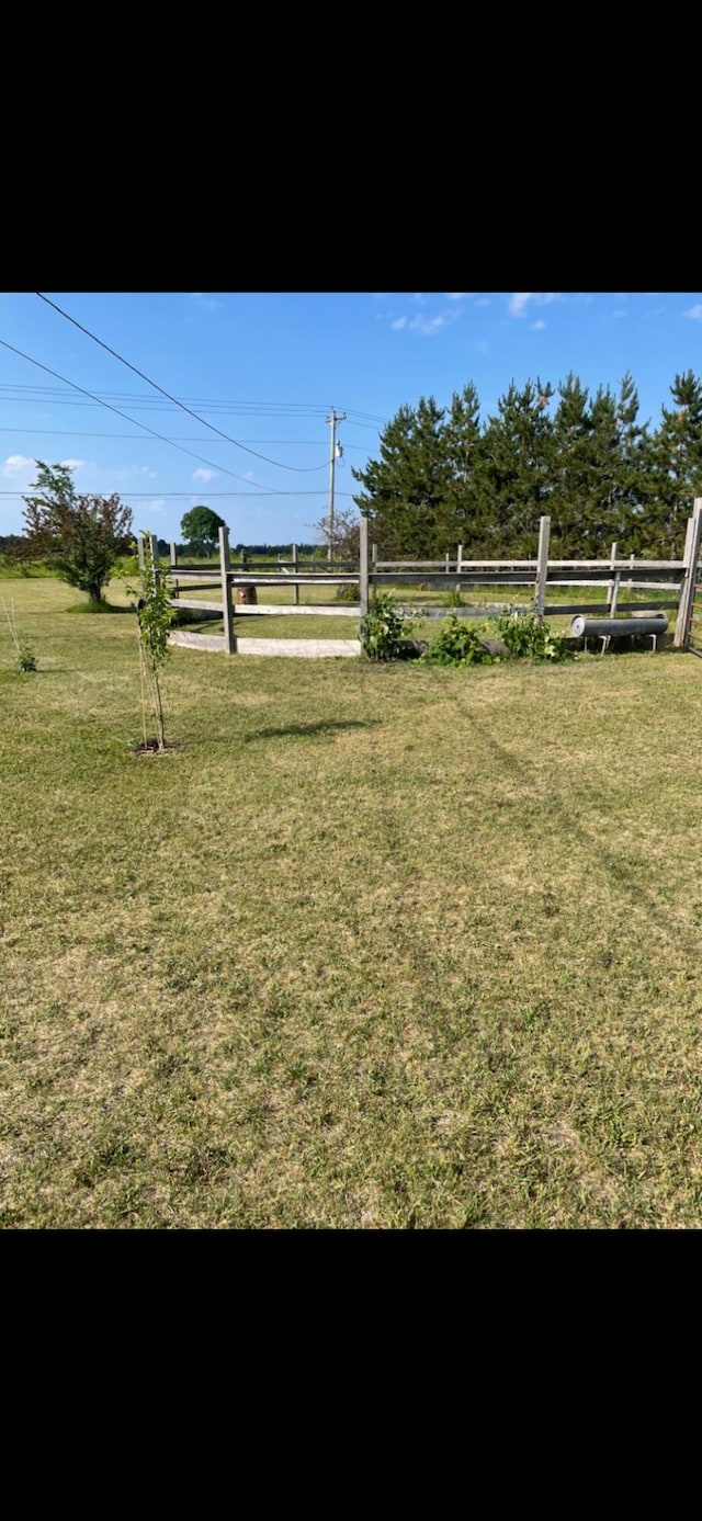 view of yard featuring a rural view and fence