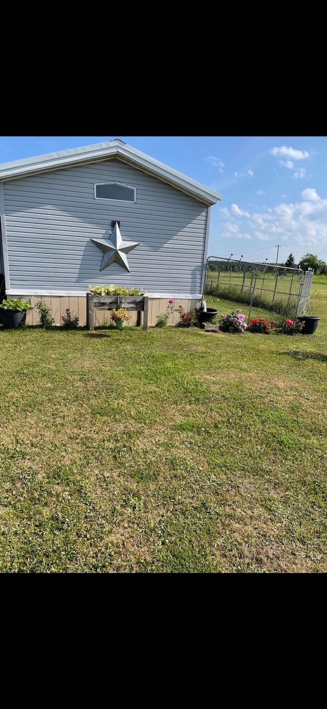 view of property exterior with a yard and fence