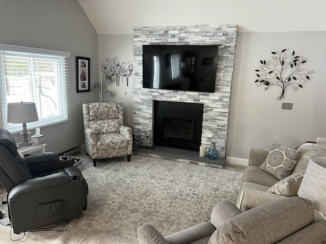 living room featuring lofted ceiling, wood finished floors, a fireplace, and baseboards