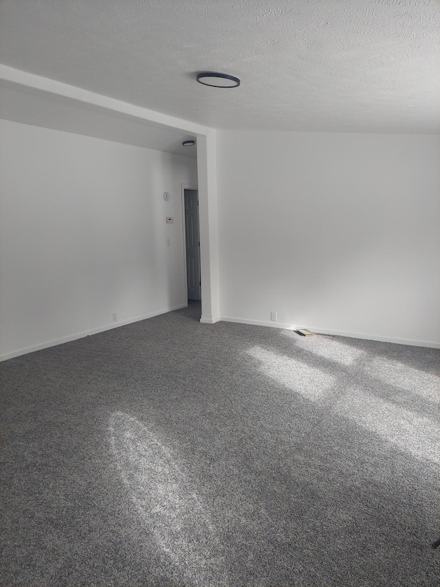 carpeted empty room featuring baseboards and a textured ceiling