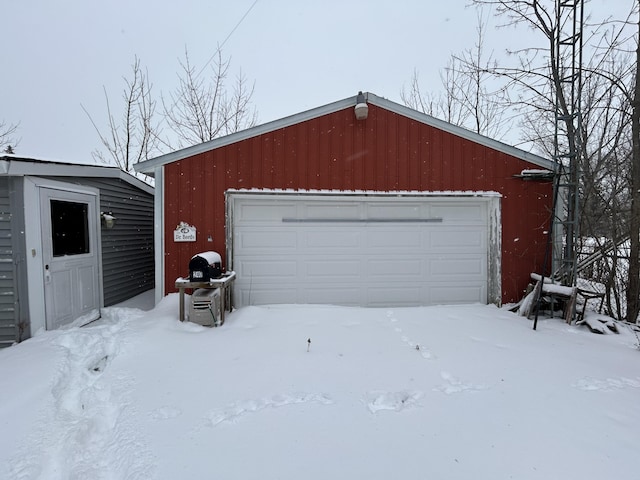 snow covered garage with a garage