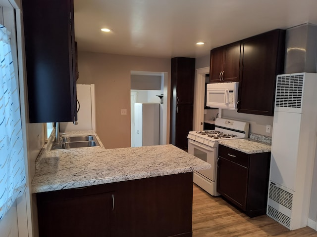 kitchen with recessed lighting, white appliances, light wood-style floors, and dark brown cabinetry