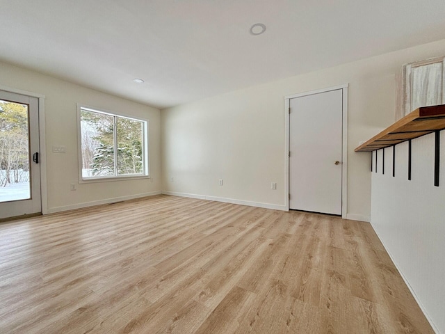 interior space with baseboards and light wood-style floors