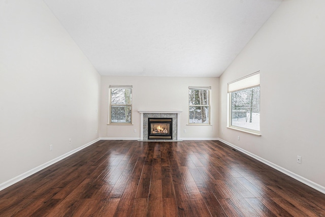 unfurnished living room featuring a fireplace, lofted ceiling, dark wood-style floors, and baseboards