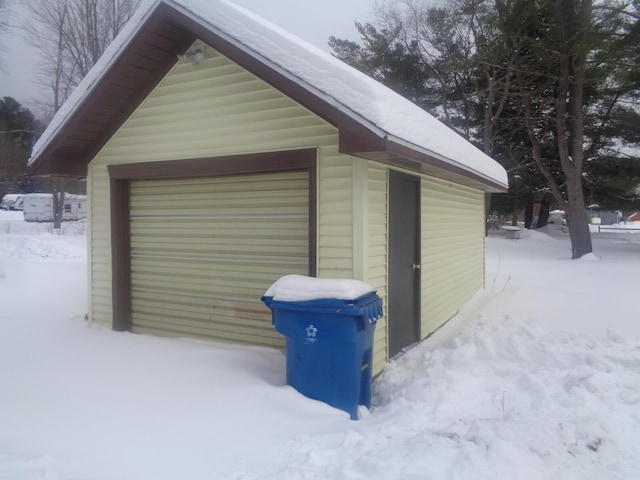 snow covered garage featuring a detached garage