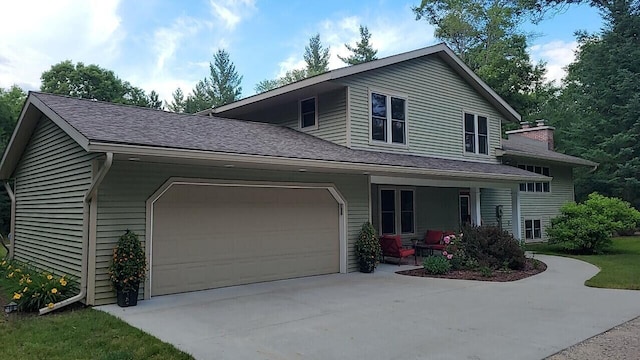 view of front of house with a garage, driveway, and roof with shingles