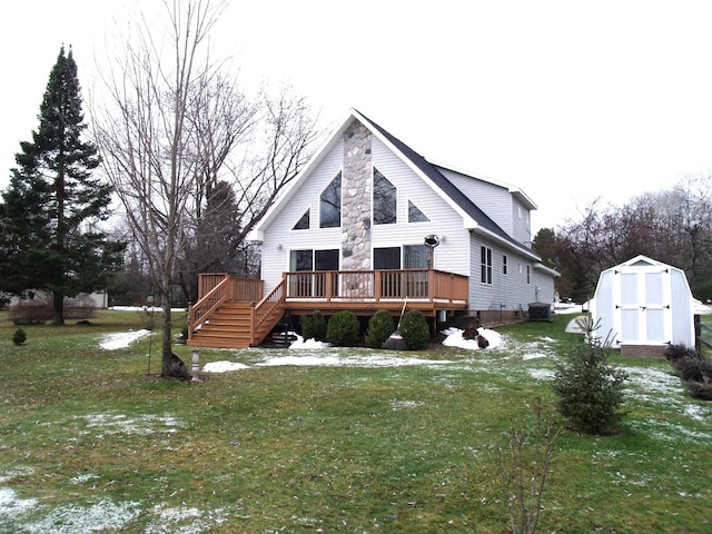 rear view of property featuring a wooden deck, a yard, stairs, an outdoor structure, and a storage shed