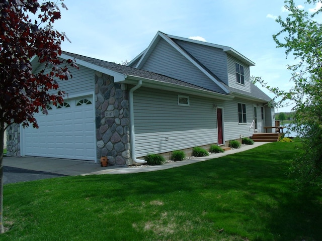 15117 Valley Dr, Wolverine, MI 49799 - view of side of home with a garage, a lawn, driveway, roof with shingles, and stone siding