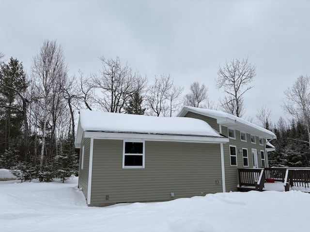 view of snow covered exterior featuring a wooden deck