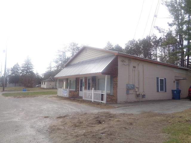 5407 W Houghton Lake Dr, Houghton Lake, MI 48629 - view of front facade with brick siding and covered porch