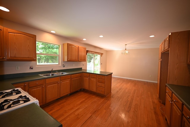 kitchen featuring dark countertops, a peninsula, and a sink