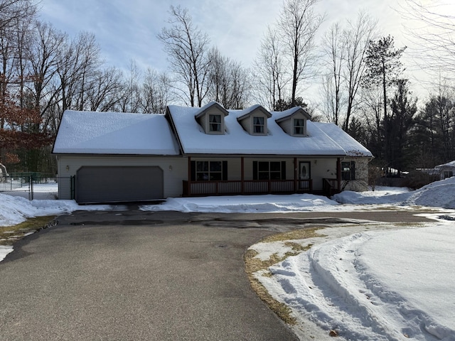 view of front of home featuring a garage, a porch, driveway, and fence