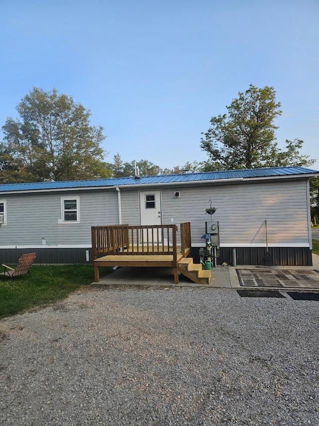 back of property with metal roof and a deck