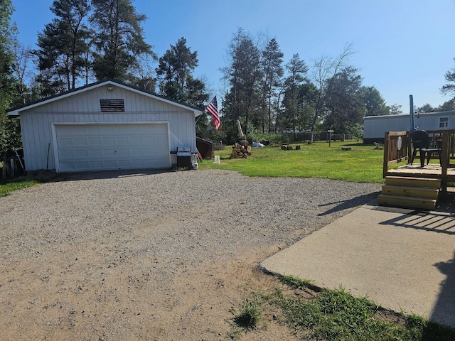 view of yard with a detached garage and an outbuilding