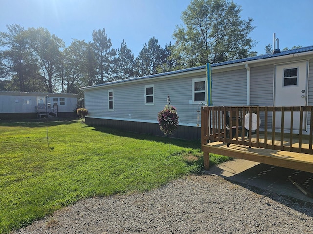 rear view of property featuring a wooden deck and a yard