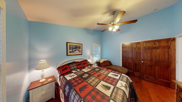 bedroom featuring a closet, lofted ceiling, wood finished floors, and a ceiling fan