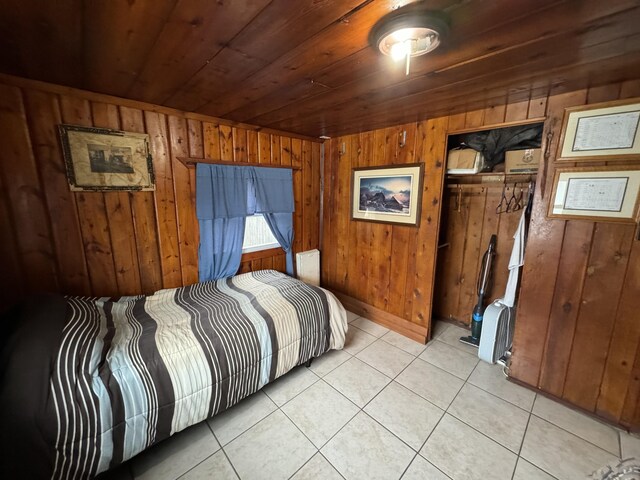 bedroom featuring light tile patterned floors, wood ceiling, and wood walls