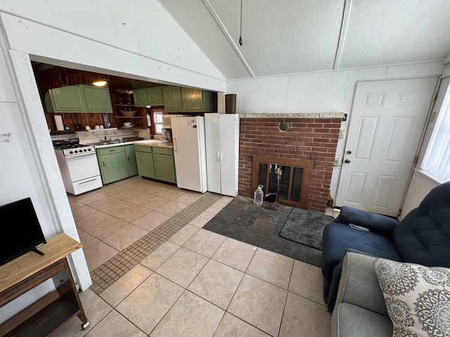 kitchen with open floor plan, white appliances, light tile patterned floors, green cabinetry, and vaulted ceiling