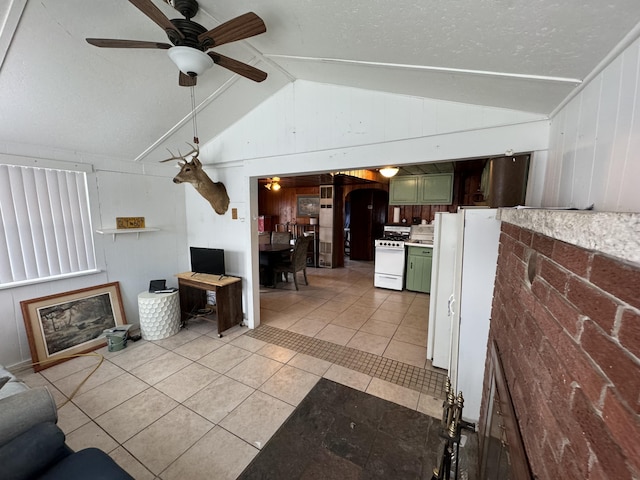 living area with ceiling fan, lofted ceiling, a textured ceiling, and light tile patterned flooring