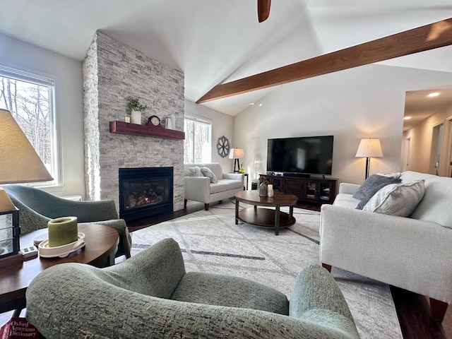 living room featuring beamed ceiling, a fireplace, and high vaulted ceiling