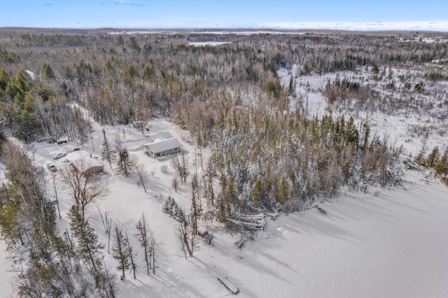 snowy aerial view featuring a forest view