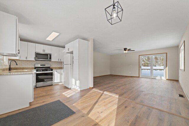 kitchen with visible vents, a sink, decorative backsplash, light countertops, and stainless steel appliances