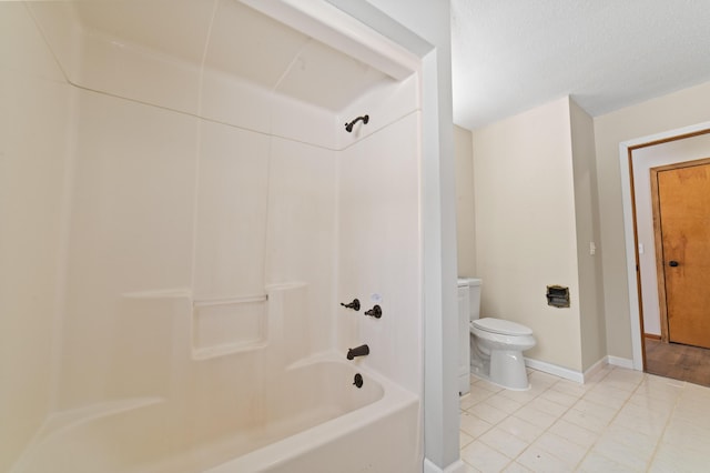 full bath with tile patterned flooring, baseboards, toilet, shower / tub combination, and a textured ceiling