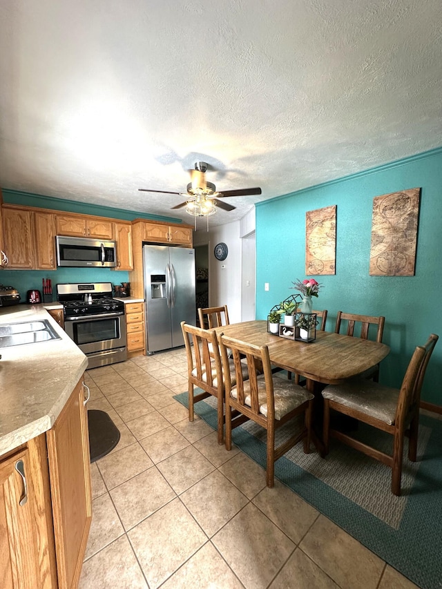 dining space with light tile patterned floors, a textured ceiling, and ceiling fan