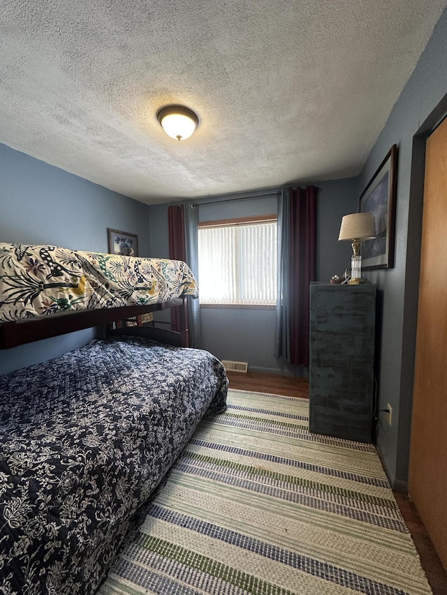 bedroom featuring visible vents and a textured ceiling