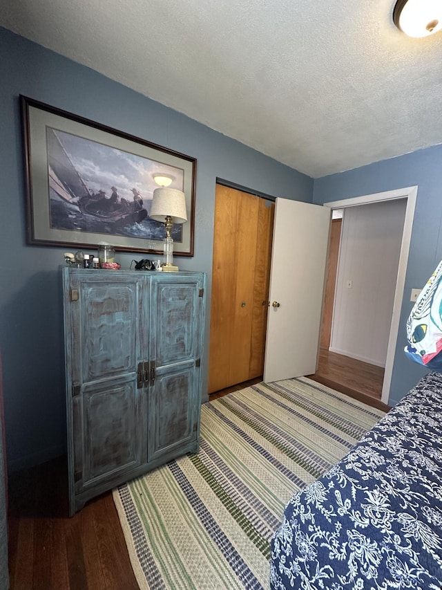 bedroom featuring a textured ceiling and wood finished floors