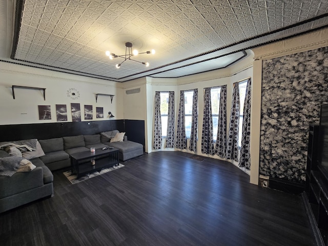 living area with a notable chandelier, an ornate ceiling, and wood finished floors