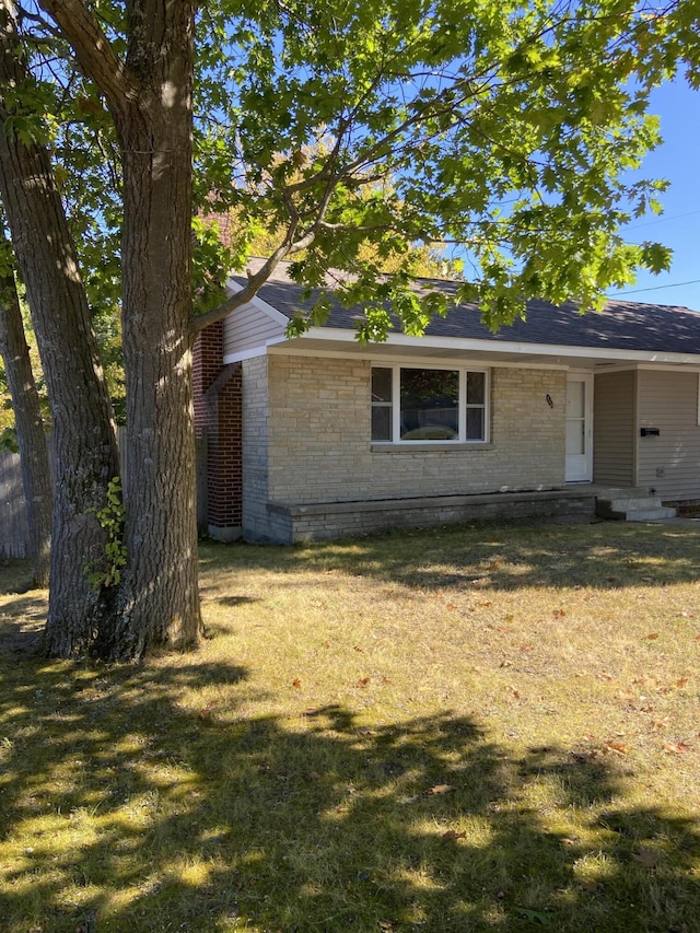 view of front of home featuring brick siding and a front yard