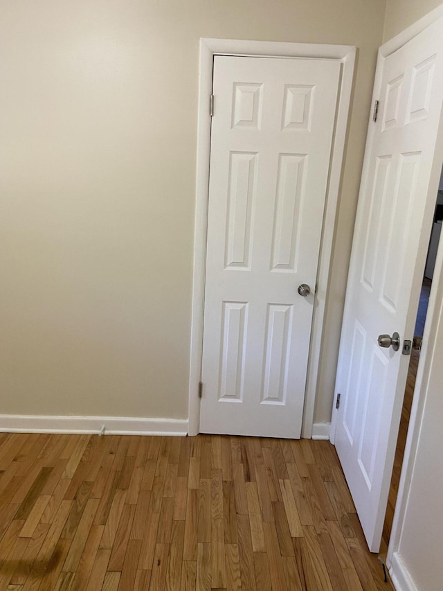 interior space featuring baseboards and wood finished floors