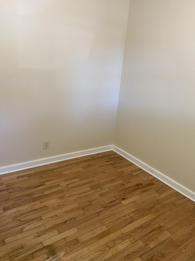 empty room featuring baseboards and light wood-style floors