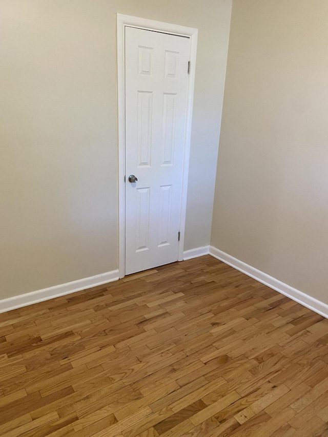 empty room featuring light wood-type flooring and baseboards