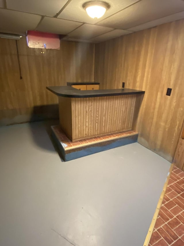 bar with wooden walls, a bar, and a paneled ceiling