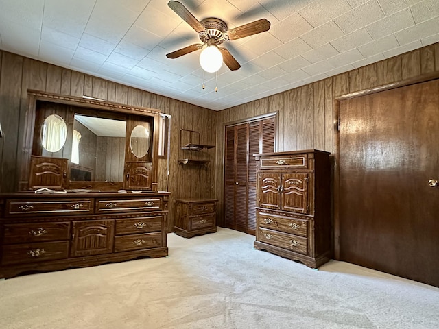 916 W First St, Cheboygan, MI 49721 - bedroom with wood walls, ceiling fan, and light carpet