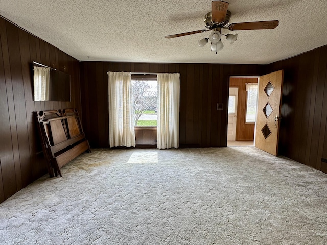 916 W First St, Cheboygan, MI 49721 - interior space with a textured ceiling, a healthy amount of sunlight, ceiling fan, and light carpet