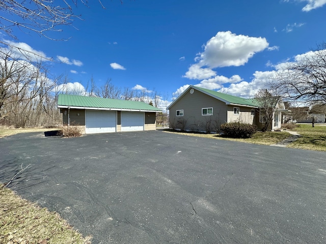 916 W First St, Cheboygan, MI 49721 - view of property exterior featuring an outbuilding, metal roof, and a garage