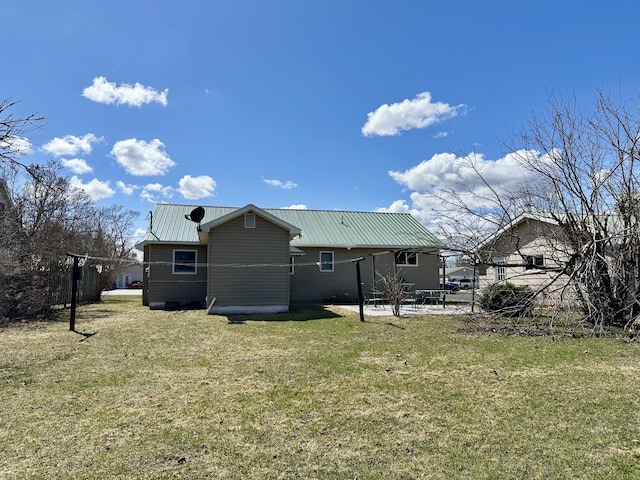 916 W First St, Cheboygan, MI 49721 - back of property with a patio area, metal roof, and a lawn