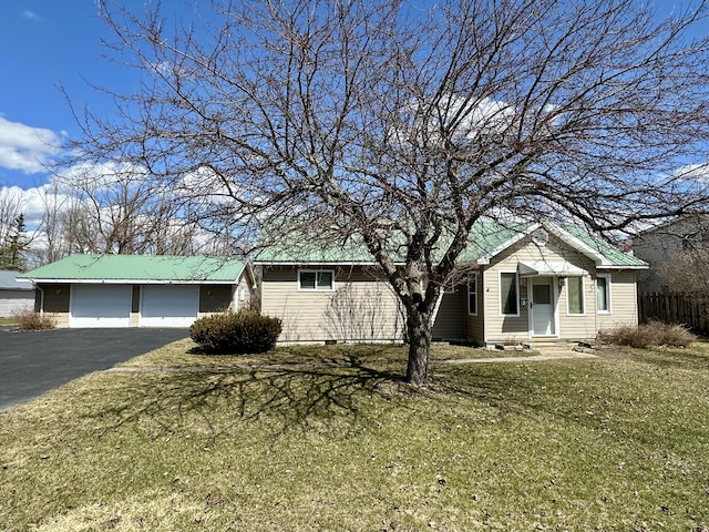 916 W First St, Cheboygan, MI 49721 - view of front of property with metal roof, aphalt driveway, entry steps, and a front lawn
