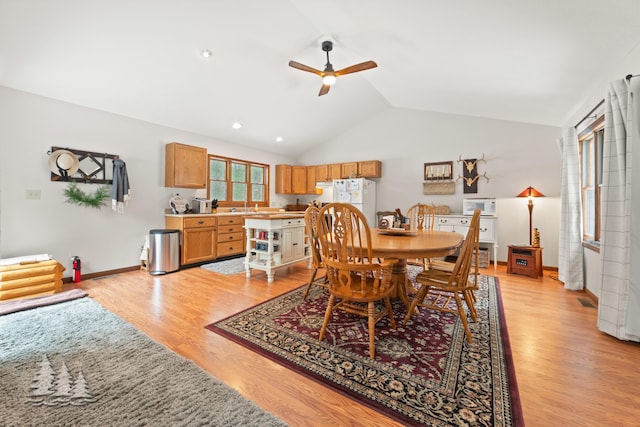 dining room featuring baseboards, light wood-style floors, lofted ceiling, and a ceiling fan