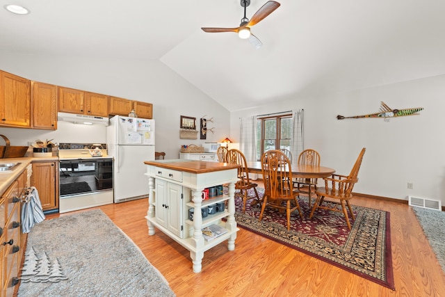 kitchen featuring visible vents, under cabinet range hood, range, freestanding refrigerator, and open shelves