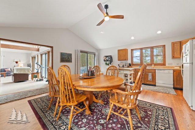 dining area with a healthy amount of sunlight, light wood-type flooring, ceiling fan, and vaulted ceiling