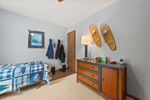 bedroom with baseboards and light carpet