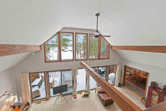 interior space featuring lofted ceiling with beams, carpet, and ceiling fan