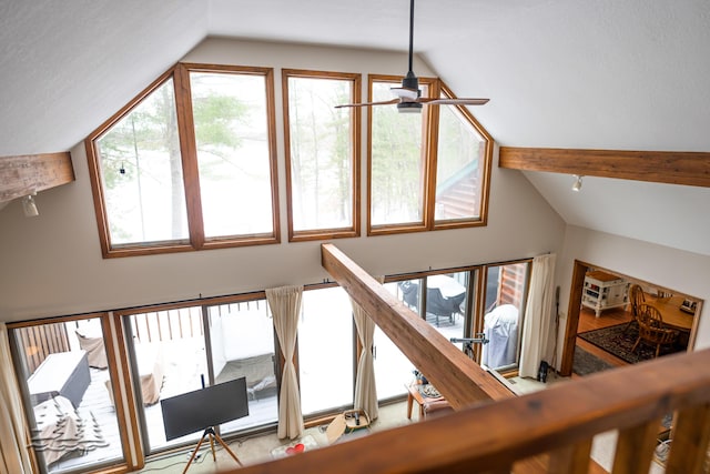 interior space with beam ceiling and a ceiling fan