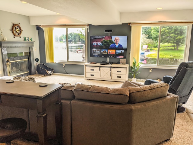 living area featuring baseboards, carpet, and a glass covered fireplace