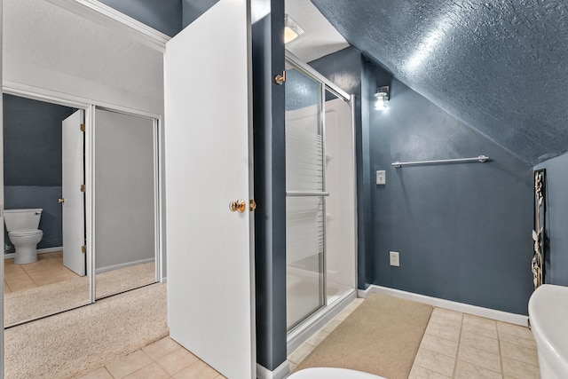 full bathroom with toilet, lofted ceiling, a stall shower, a textured ceiling, and baseboards