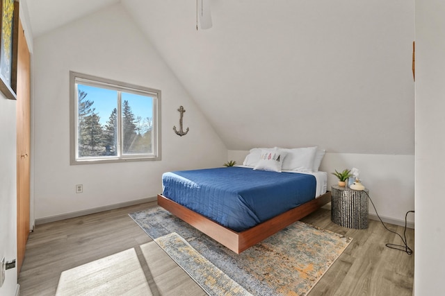 bedroom featuring ceiling fan, baseboards, lofted ceiling, and wood finished floors